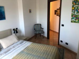 1 dormitorio con 1 cama y 1 silla en una habitación en Apartment Verdiano, en Parma