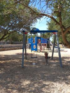 een hond die naast een schommel in een park staat bij Vlasta in Mali Lošinj