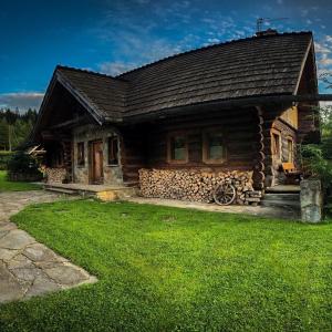 a log cabin with a green lawn in front of it at Domek na Skałce in Żabnica