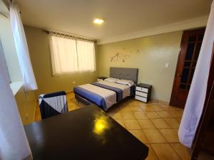 een slaapkamer met een bed en een tafel. bij Samana Wasi, Lugar encantador en Cusco in Cuzco