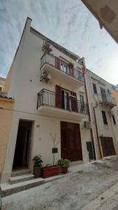 a white building with two balconies on it at Casa Vacanze Gloria in Castellammare del Golfo