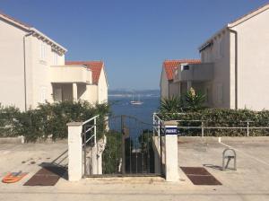 une porte offrant une vue sur l'eau entre deux bâtiments dans l'établissement Apartment Andrea, à Sutivan