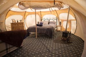 a bedroom with a bed in a tent at Tone valley view glamping in Wellington