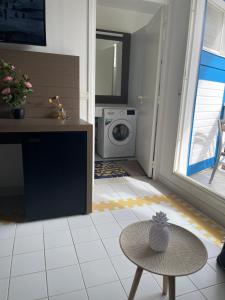 eine Waschküche mit einer Waschmaschine und einem Tisch in der Unterkunft Studio 25 m Manganao Joela 4 personnes avec machine a laver in Saint-François