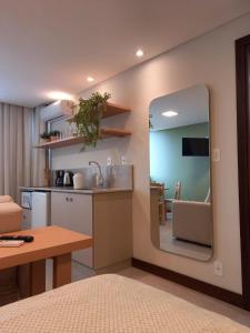 cocina con espejo, mesa y encimera en Residence Farol - Loft 206, en Laguna