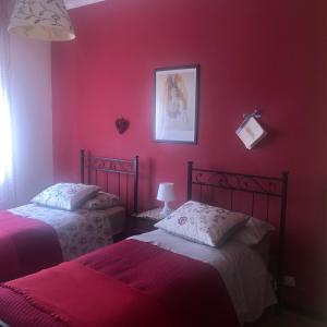2 camas en una habitación roja con paredes rojas en Apartment Montebello, en Parma