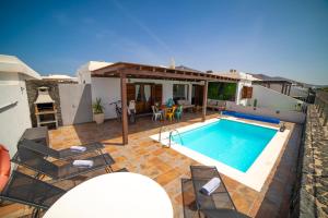una villa con piscina y una casa en Villa Alba, en Playa Blanca