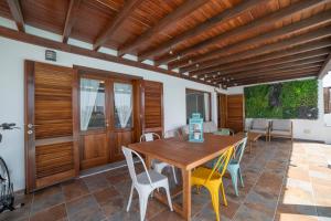 una sala da pranzo con tavolo e sedie in legno di Villa Alba a Playa Blanca