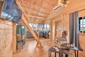 a log cabin with a staircase and chairs in a room at Wood Village in Winiec