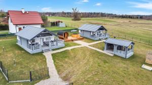 a group of three houses on a grass field at Wood Village in Winiec