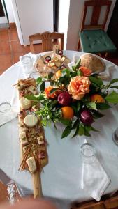 a table with a bouquet of flowers and food on it at Casa dos Avós in Alcaria