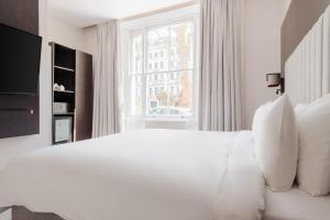 Rove Hotel London Paddington tesisinde bir odada yatak veya yataklar