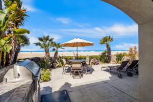 a patio with an umbrella and chairs and the beach at Brighton Bungalow in San Diego