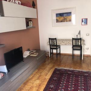 a living room with a flat screen tv and two chairs at Apartment Parmense in Parma