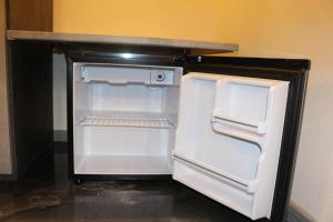 an empty refrigerator with its door open in a kitchen at Via Cavour 19, Camere del Conte in Iglesias
