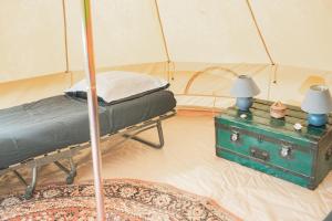 - une chambre avec un lit et une table dans une tente dans l'établissement Le repère du pin sec - Glamping & Surfcamp, à Naujac-sur-Mer