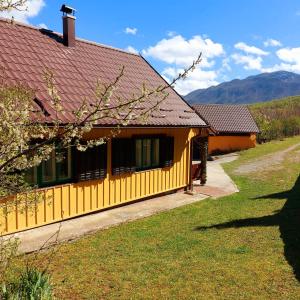 ein gelbes Haus mit braunem Dach in der Unterkunft Honey house Lika in Gospić