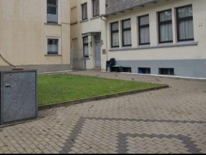 a building with a trash can in the middle of a courtyard at Ferienhaus Zoe 120 m2 in Solingen