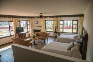a living room with two beds and a television at Hotel Playa de Cortes in Guaymas
