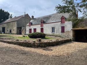 ein altes Steingebäude mit roten Rollläden darauf in der Unterkunft Maison La Reine in La reine