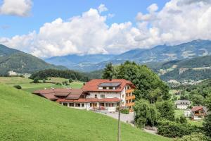 a house on a hill with mountains in the background at Apartment Pichlerhof in San Lorenzo di Sebato