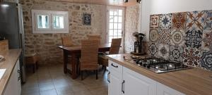 a kitchen with a table and a stove top oven at Gîte Maelga in Cartelègue