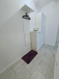 ein weißes Zimmer mit einem Spiegel und Fliesenboden in der Unterkunft Apartament Maika Świnoujście in Świnoujście