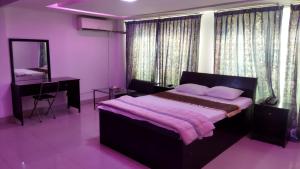 1 dormitorio con cama, escritorio y espejo en Hotel Rose Garden en Chittagong