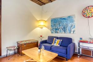 ローマにあるSANTA MARIA MAGGIORE Apartmentのリビングルーム(青いソファ、テーブル付)