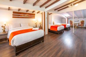 a large bedroom with two beds and a table at Hotel Monasterio del Inka in Cusco
