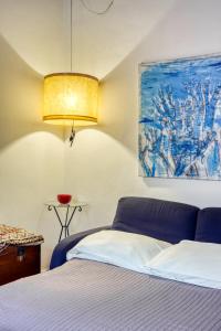 ローマにあるSANTA MARIA MAGGIORE Apartmentのベッドルーム1室(ベッド1台付)が備わります。壁には絵画が飾られています。