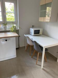 kuchnia z białym stołem i kuchenką mikrofalową w obiekcie Ferienwohnung Diana und Manuel w mieście Weinheim