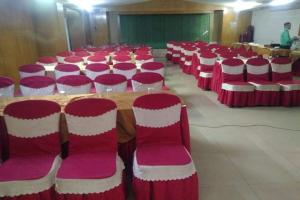 una stanza con sedie rosse e bianche e un tavolo di Hotel Rose Garden a Chittagong