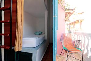 a room with a bed and a chair on a balcony at República Hostel Cartagena in Cartagena de Indias
