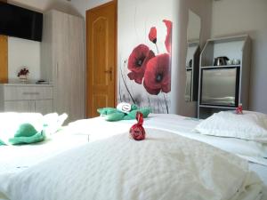 a bedroom with two beds with stuffed animals on them at Margaréta Panzió in Sárospatak