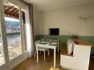 cocina con mesa blanca y balcón en Studio La Pinède Plage à 150m Clim Place de Parking Privée, en Saint-Cyr-sur-Mer