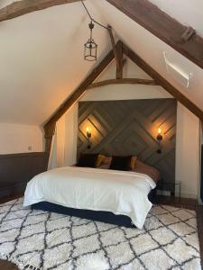 a bedroom with a large bed in an attic at La Seigneurie des Ondes in Saint-Benoît-des-Ondes