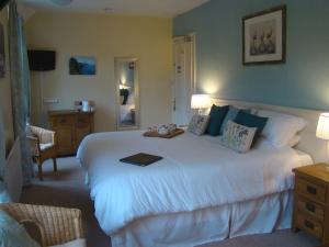 a bedroom with a large white bed in a room at Pine Lodge in Lynton