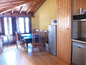 een keuken en eetkamer met een tafel en een koelkast bij Casa Rural la Catedral de la Montaña in Lois