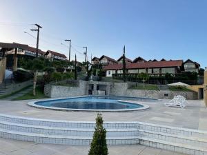 巴納內拉斯的住宿－Chalé Serrano，庭院内的游泳池,庭院内有建筑背景