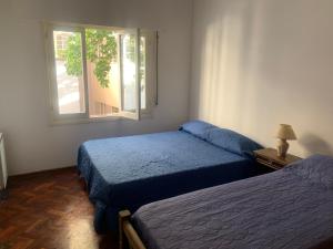 a bedroom with two beds and a window at Hostel la Embajada in Mendoza