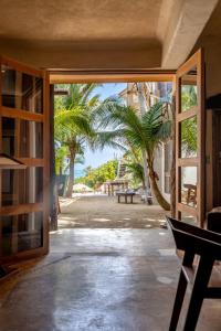 eine offene Tür zu einer Terrasse mit Palmen in der Unterkunft La Posada del Sol Boutique Hotel Tulum in Tulum