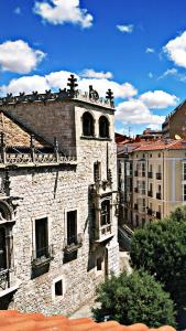 an old stone building with a clock tower in a city at Mía Suites I Centro Histórico - PARKING & WIFI FREE in Burgos