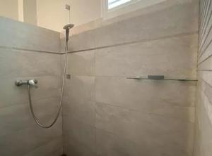 een badkamer met een douche en een slang aan de muur bij Villa Écrin de Nature in Sainte-Rose +19 foto's