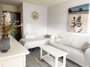 a white living room with a couch and a bed at El Horriu in Llanes