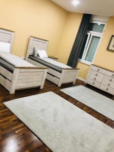 a room with two beds and two rugs at Swiss Central Luxury Apartment 132m2 in Sarajevo