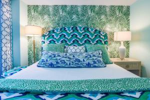 a bedroom with a bed with a blue headboard and pillows at Array of Sunshine Condo in Isle of Palms +46 photos