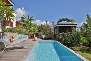 einen Pool mit Terrasse und ein Haus in der Unterkunft Gite La Tortue Bleue in Bouillante