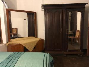 1 dormitorio con armario de madera y espejo en Central residence Rajagiriya-Entire House, en Sri Jayewardenepura Kotte