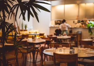 Ein Restaurant mit Tischen und Stühlen und einer Person im Hintergrund in der Unterkunft Ipanema Inn Hotel in Rio de Janeiro